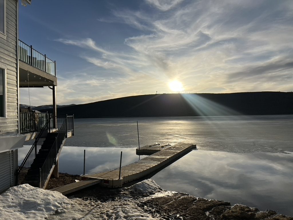Winter sun over the frozen reservoir, with the stairs from the house leading down to the dock