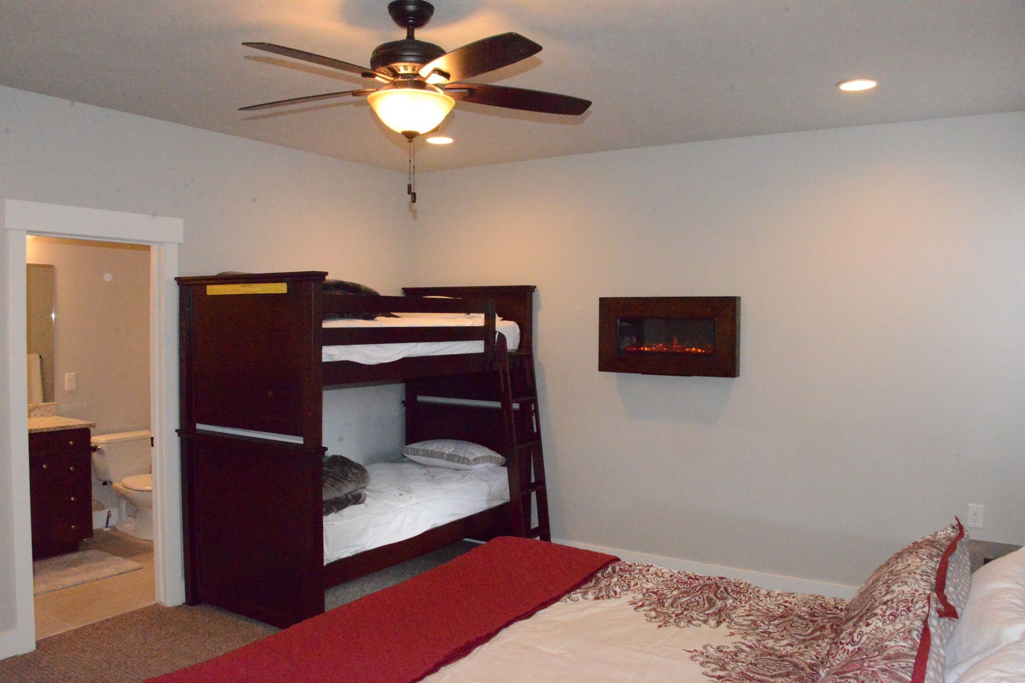 Bedroom with twin bunk bed, wall fireplace and attached bath